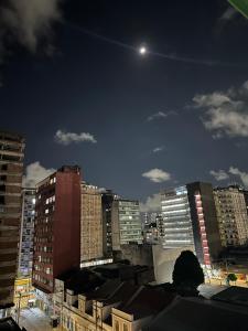 a view of a city at night with the moon at Quarto Astral in Recife
