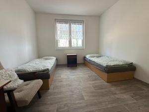 two beds in a room with a window at SK Delfín Jesenice Cheb in Cheb