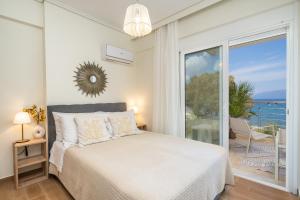 a bedroom with a bed and a view of the ocean at Aura Seaside Apartment in Karavomylos