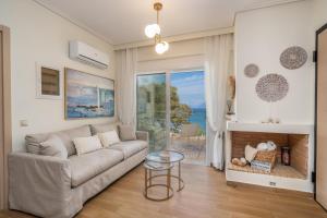 a living room with a couch and a fireplace at Aura Seaside Apartment in Karavomylos