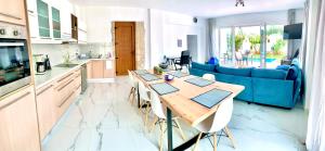 a kitchen and living room with a table and a blue couch at Hayeks Villa private pool near the beach in Daratso +9 photos