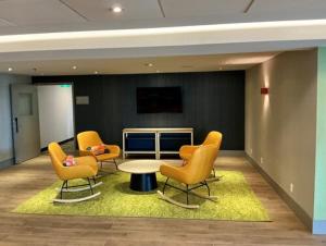 a waiting area with chairs and a table in an office at Spark by Hilton Montreal Brossard in Brossard