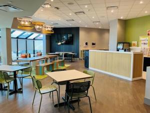 a restaurant with tables and chairs in a cafeteria at Spark by Hilton Montreal Brossard in Brossard