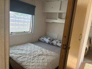 a small bedroom with a bed and a window at het straatje in Scherpenisse