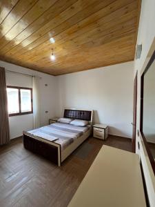 a bedroom with a bed and a wooden ceiling at Bert-House close to the sea in Lezhë