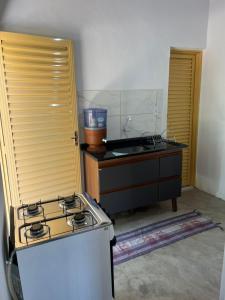 a kitchen with a stove and a sink at Cantinho da Naná in Cavalcante