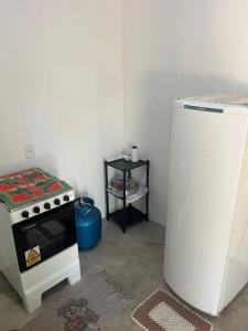 a small kitchen with a stove and a refrigerator at Cantinho da Naná in Cavalcante