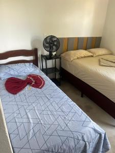 a bedroom with two beds and a fan at Cantinho da Naná in Cavalcante