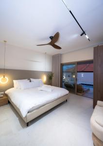 a bedroom with a bed and a ceiling fan at אלאיה סוויטות יוקרה in Shomera +32 photos