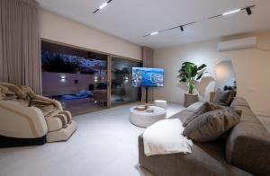 a living room with a couch and a flat screen tv at אלאיה סוויטות יוקרה in Shomera