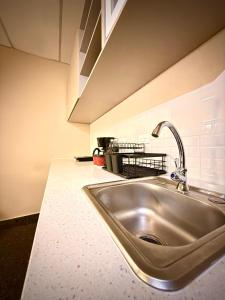 a kitchen counter with a stainless steel sink at Cardedeu Suites in San Salvador +47 photos