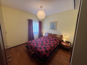 a bedroom with a bed with a red comforter at Vila Praia House in Vila Praia de Âncora +7 photos