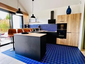 a kitchen with blue tiles on the floor at L'Instant Cottage, Chic et Spa près d'Amboise in Saint-Règle