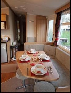 a table with plates and dishes on it in a living room at Jaynes Holiday Caravan Marton Mere in Blackpool