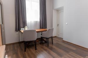 a dining room table with two chairs and a window at Galaktyka Hotel in Stantsiya Biskovitse
