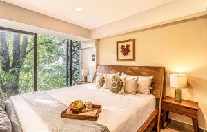 a bedroom with a bed and a large window at Kukun Tonala 30 Roma in Mexico City
