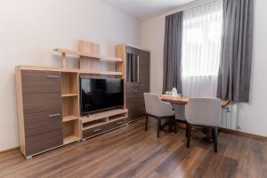 a living room with a table and a tv and a room with a dining table at Galaktyka Hotel in Stantsiya Biskovitse