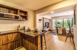 a kitchen with a bar and a living room at Kukun Tonala 30 Roma in Mexico City