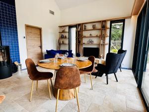 a dining room with a wooden table and chairs at L'Instant Cottage, Chic et Spa près d'Amboise in Saint-Règle