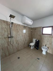 a bathroom with a shower and a toilet at Bert-House close to the sea in Lezhë +37 photos