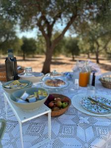 a table with plates of food and a bowl of fruit at Trullo Moi in Ostuni