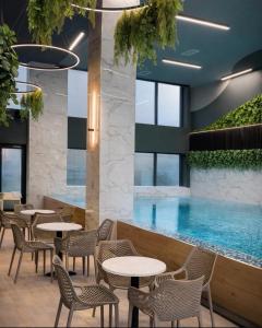 a restaurant with a pool and tables and chairs at I&I Tesla IV in Kragujevac