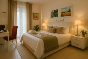 a bedroom with a white bed with a desk and a chair at Green House Matera Centro in Matera