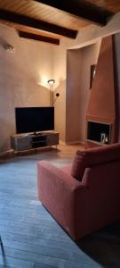 a living room with a red couch and a flat screen tv at Le Contrade in Amelia
