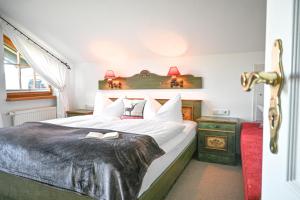 a hotel room with a bed with two books on it at Gästehaus Alpenruh in Fischen