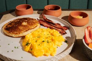 a plate of breakfast food with eggs bacon and toast at The Cut Hotel in Medellín +86 photos