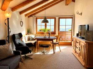 a living room with a table and a couch at Gästehaus Alpenruh in Fischen