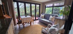 ein Wohnzimmer mit Sofa und Tisch in der Unterkunft Cavalo Guesthouse & Equestrian Estate in Drummond