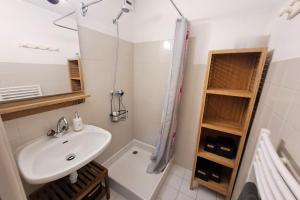 a white bathroom with a sink and a shower at Studio at the foot of the ice rink in Le Grand-Bornand