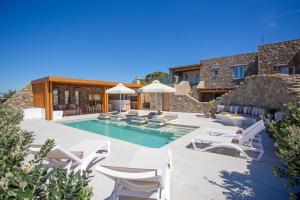 a villa with a swimming pool and patio furniture at Mystic Harmony in Mikonos