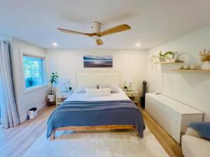 a bedroom with a bed and a ceiling fan at Low Tide Suite - Modern, Oceanside Suite with King Bed, Resort Pool & Hot Tub in Nanoose Bay