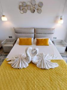 two white swans are sitting on a bed at Sunset Cliffs Luxury Apartment Benidorm in Benidorm