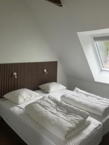 two beds with white sheets and pillows in a room at Penthouse deluxe in Hobro