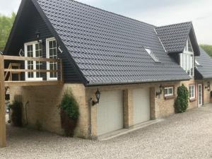 a house with a black roof and a garage at Penthouse deluxe in Hobro