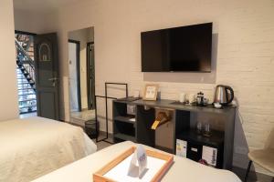 a room with a bed and a television on a wall at Trento Hotel Boutique in San Salvador de Jujuy