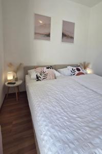 a bedroom with a large white bed with pillows at Villa Konalic in Mokošica