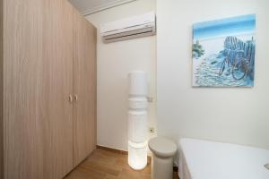 a bedroom with a bed and a painting on the wall at Aura Seaside Apartment in Karavomylos +23 photos