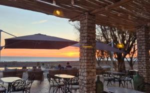 a patio with tables and chairs and an umbrella at Anima Ocean Lodges in Essaouira