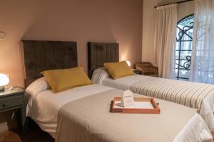 a room with two beds with a tray on top of them at Trento Hotel Boutique in San Salvador de Jujuy