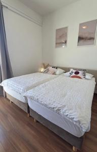 a bedroom with two beds with white sheets and a window at Villa Konalic in Mokošica