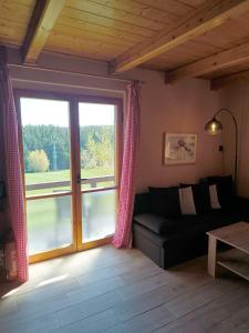 a living room with a couch and a large window at Chata Na Kačce in Borowa