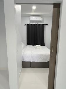a small bedroom with a bed and a black curtain at Hana residence Bangtao BeachBangtao 11 Phuket in Ban Thalat Choeng Thale