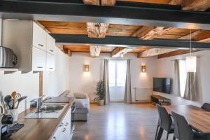 a kitchen and living room with wooden ceilings at Altes Schulhaus in Heiligenberg