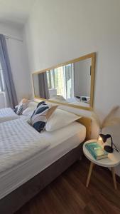 a bedroom with two beds and a table and a mirror at Villa Konalic in Mokošica