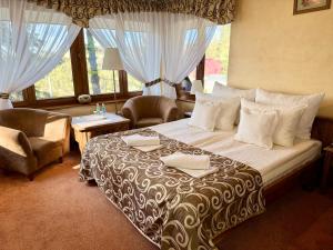 a bedroom with a large bed and a window at Hotel Dwór Karolówka in Zakopane