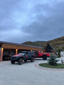 a couple of trucks parked in front of a building at Cabin&Villa Property in Târgu Ocna